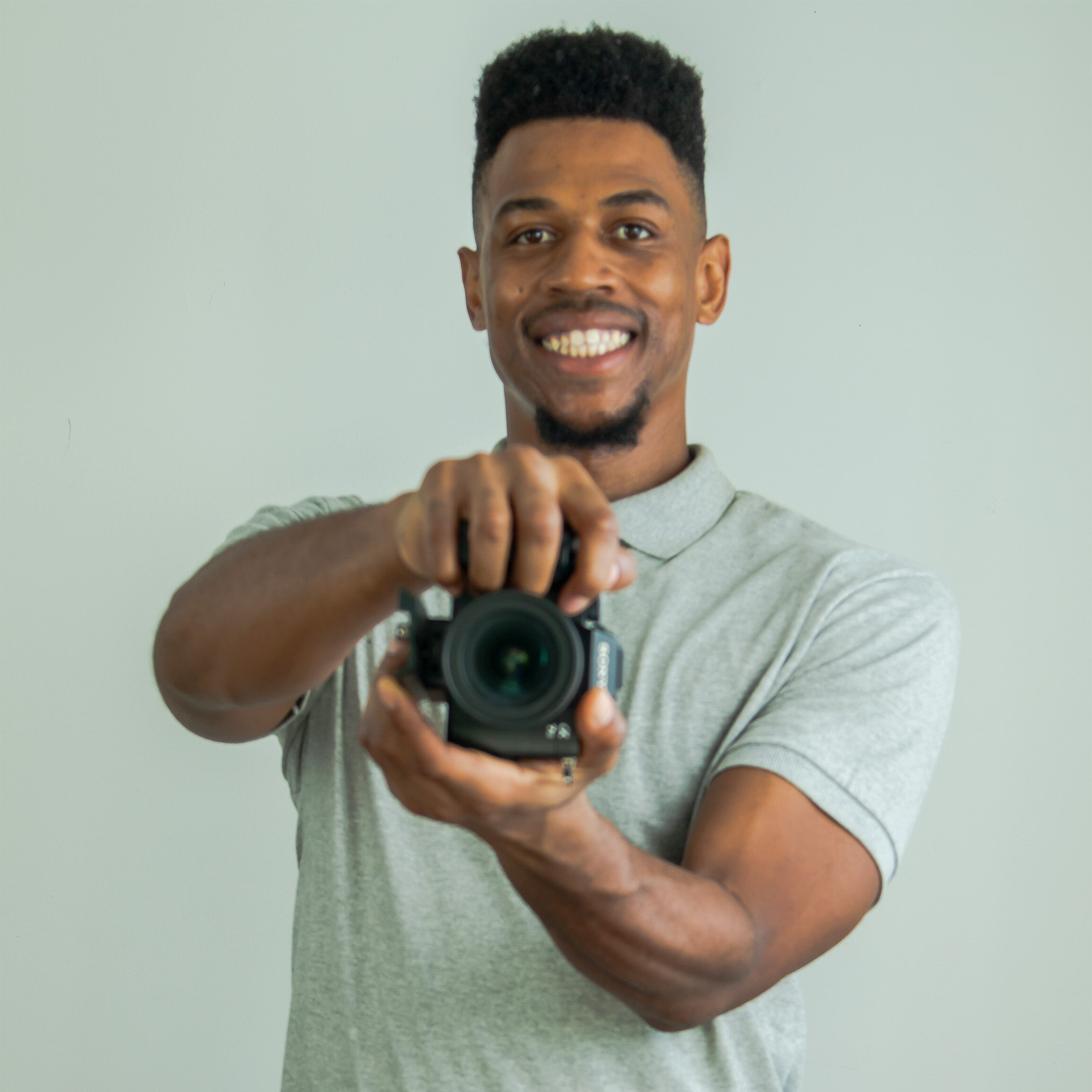 Dunbar holding a camera and smiling